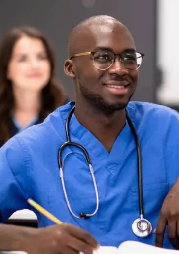 A medical student taking notes in a classroom
