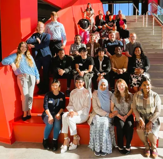 Numerous student leaders sitting on steps outside